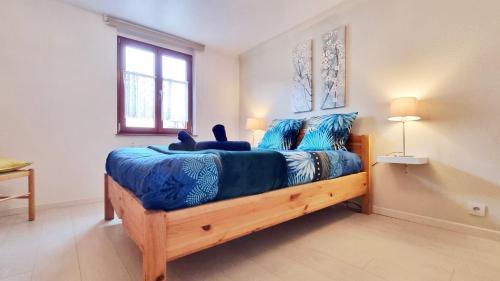 a bedroom with a bed with a blue comforter at Gite A la Fontaine Bergheim in Bergheim
