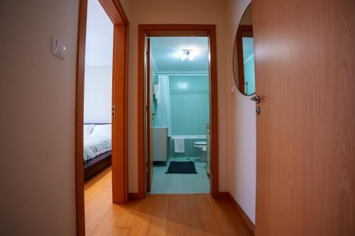 a hallway leading to a bathroom with a bed at Charlotte's Place in Ponta Delgada