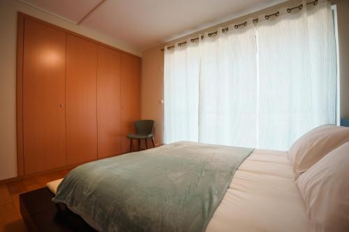 a bedroom with a large bed and a window at Charlotte's Place in Ponta Delgada