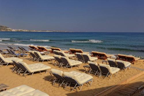 a bunch of chairs and chairs on a beach at Parthenis Hotel & Suites in Malia
