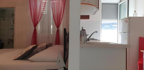 1 dormitorio con 1 cama con cortinas rojas y lavamanos en Old Town & Free Parking - Sweet Studio Apartment Dado with Balcony, en Split