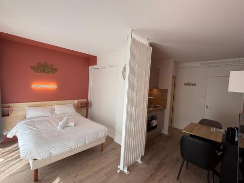 une chambre avec un lit blanc et un bureau dans l'établissement Le D'Artagnan - App 3 - Rez-de-chaussée, à Cazaubon