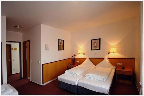 Habitación de hotel con 2 camas y 2 lámparas en Hotel Zur Linde, en Schermbeck