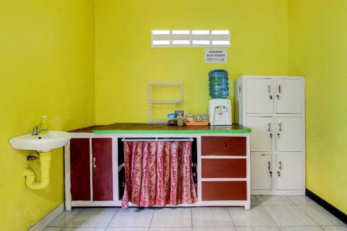 a small kitchen with a sink and a counter with a sink at Hotel O Lobak Hostel CapsuleNearAyam Goreng Terowongan in Alastuwo
