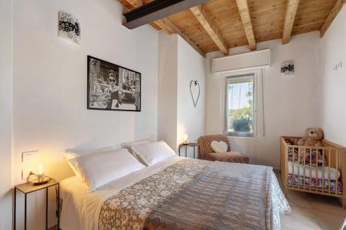 a bedroom with a bed and a chair and a window at Les Amis di Peschiera in Peschiera del Garda