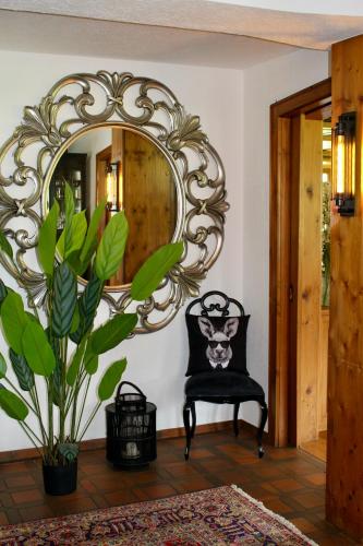 a mirror on a wall with a chair in a room at Engel 16 in Gutach
