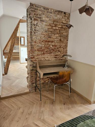 a room with a desk and a brick wall at La Villa du Clos Normand Les Petites Dalles - Maison d'hôtes in Saint-Martin-aux-Buneaux