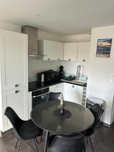 une cuisine avec une table et des chaises dans une cuisine dans l'établissement Le Channel, à Camiers