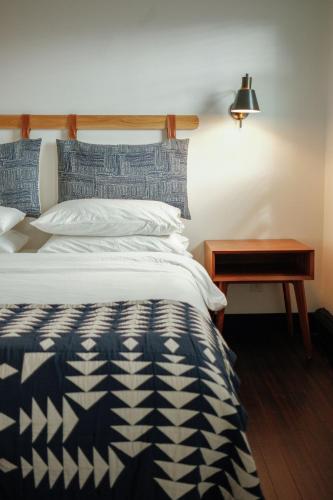 a bed with a blue and white comforter and a table at Eastwind in Windham