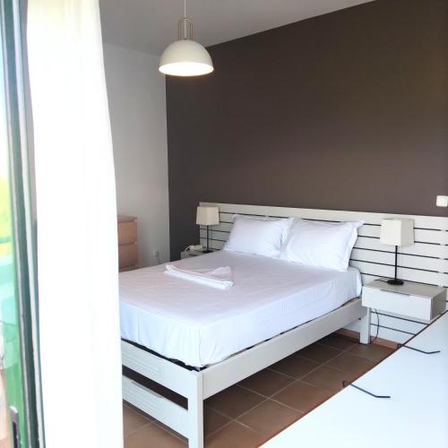 a bedroom with a bed with a white bed frame at ΣΥΜΗ View House in Mitikas