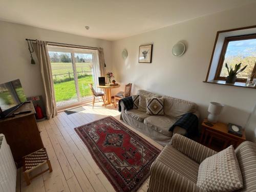 a living room with a couch and a table at Stable Cottage by Roslin Glen in Roslin