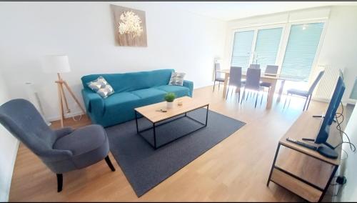 un salon avec un canapé bleu et une table dans l'établissement Professionnels de Thiais, Rungis, Choisy, à Thiais
