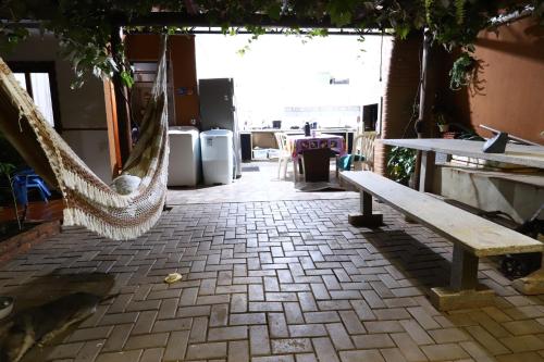a patio with a hammock and a table and chairs at Quarto em Foz do Iguaçu in Foz do Iguaçu