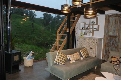 a living room with a couch and a large window at Chocó 701 La Reserva- Casa Huaicundo in Nanegalito
