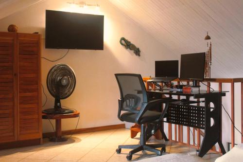 a room with a desk with a computer and a fan at Samara Beach Las Palmeras Condo with Ocean view in Sámara