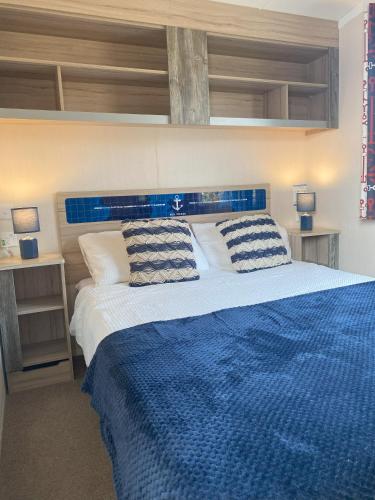 a bedroom with a blue bed with two pillows at Bude Holiday Resort Peace And Quiet in Bude