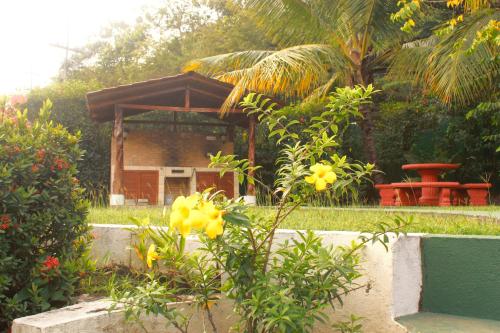 a garden with a small house with yellow flowers at Samara Beach Las Palmeras Condo with Ocean view in Sámara