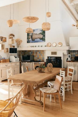 une cuisine et une salle à manger avec une table et des chaises en bois dans l'établissement Domaine de la Ruade, à La Chapelle-Saint-Sauveur