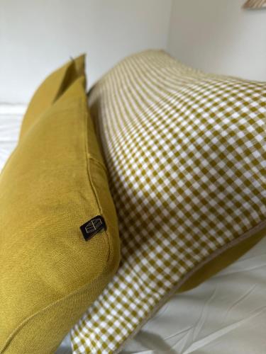 a yellow pillow sitting on top of a bed at Home Cassis - Maison Méditerranée - Piscine chauffée à 30c in Cassis