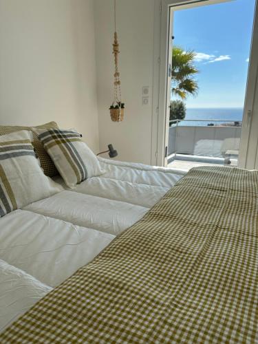 a white couch in a room with a large window at Home Cassis - Maison Méditerranée - Piscine chauffée à 30c in Cassis