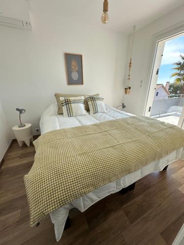 a bedroom with two beds and a large window at Home Cassis - Maison Méditerranée - Piscine chauffée à 30c in Cassis