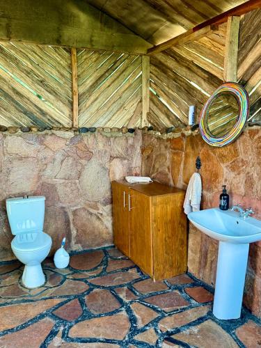 a bathroom with a toilet and a sink at 2 Authentic Mara Bush Cottages in Sekenani