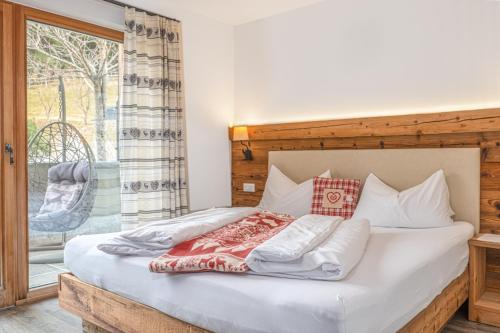 a bedroom with a bed with a large window at Alpine Mountain Chalet in San Vigilio Di Marebbe