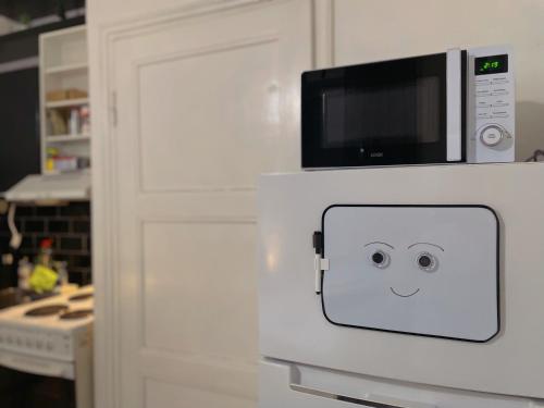 a white door with a face drawn on it in a kitchen at Nextdoor Host Eco-lodge 24h Self Check-in with Bathtub in Helsinki