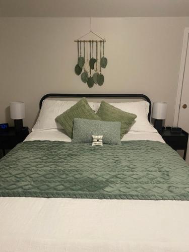 a bed with a green blanket and two pillows at Bernice Mae's Ocean View in Lewisporte