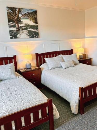 a bedroom with two beds and a painting on the wall at Hilo Town Inn in Hilo