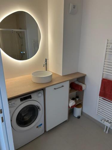 a bathroom with a washing machine and a mirror at Casa Alma in Camiers