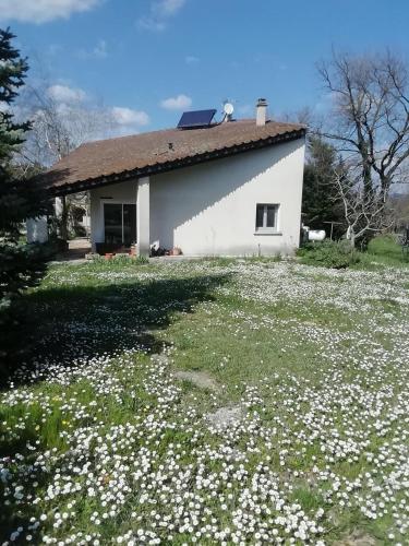 a white house with a field of flowers at Melograni in Chomérac