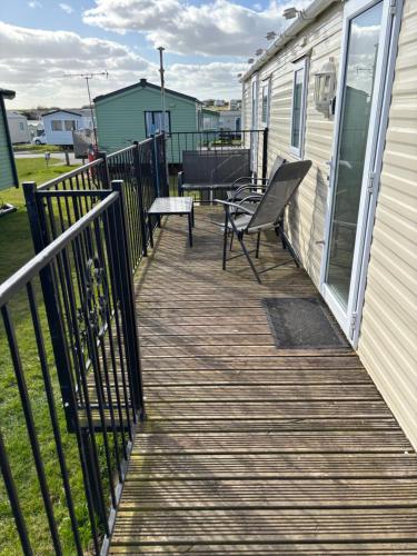 a deck with a chair and a bench on a house at Jay 35 4 bed sleeps up to 8 dog friendly caravan Thornwickbay haven site on East coast in Flamborough