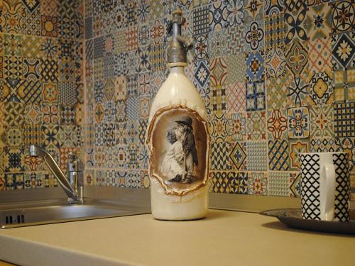 Eine Flasche mit einem Bild eines Mannes auf einem Waschbecken. in der Unterkunft The Kiss Apartment in Timişoara