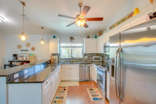 a kitchen with white cabinets and a stainless steel refrigerator at Little Gasparilla Island Escape with 2 Decks! in Placida