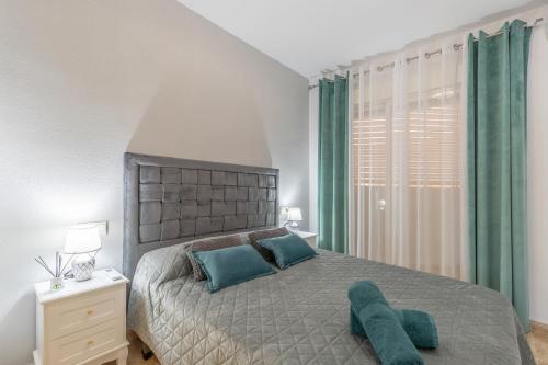 a bedroom with a large bed with blue pillows at Calpe Vacaciones in Calpe