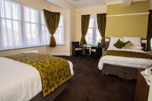 a hotel room with two beds and a desk at Bloomfield Brewhouse in Blackpool