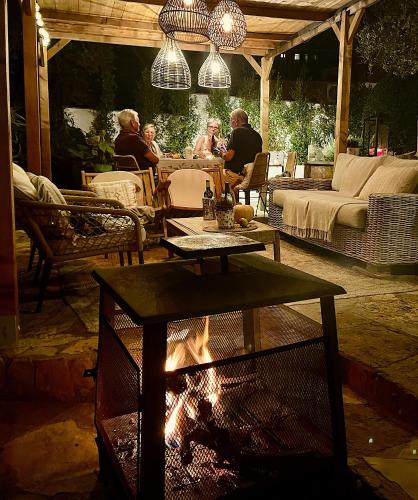 a group of people sitting around a fire in a yard at Villa Marlena, Calonge, Costa Brava,1 luxe private studio-appartement with private pool in quiet area, adults only, Catalonia, Spain in Calonge