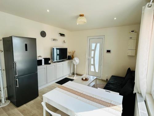 - un salon avec un réfrigérateur noir et une télévision dans l'établissement Sublime Appt refait à neuf !, à Argenteuil