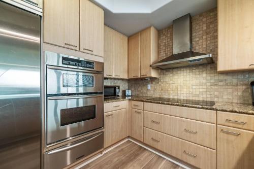 a kitchen with wooden cabinets and stainless steel appliances at Caribe D-0404 in Orange Beach