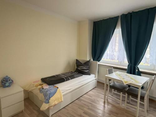 a small bedroom with a bed and a table at Ferienwohnung am Neumarkt in Auerbach