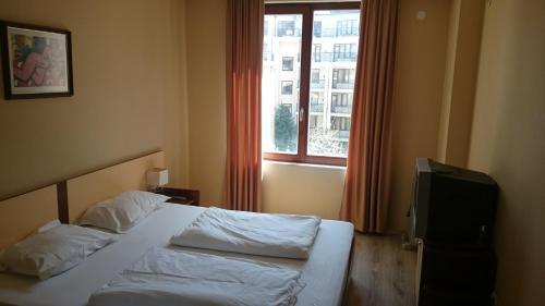 a hotel room with a bed and a window at Krassy summer apartment in Golden Sands