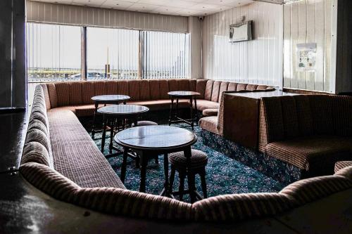 a waiting room with couches and tables and windows at Harlands Hotel in Blackpool