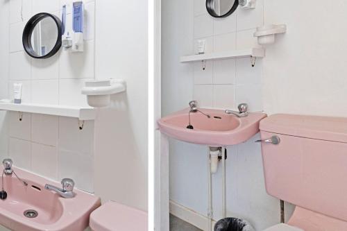 a pink bathroom with a sink and a toilet at Harlands Hotel in Blackpool
