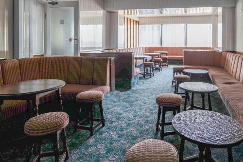 a waiting room with couches and tables and stools at Harlands Hotel in Blackpool