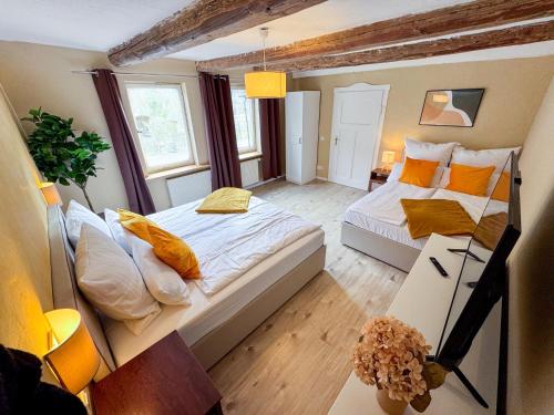 une petite chambre avec deux lits et une table dans l'établissement Haus Ludwig - Saniertes Fachwerkhaus im Harz - 12 Personen, à Thale