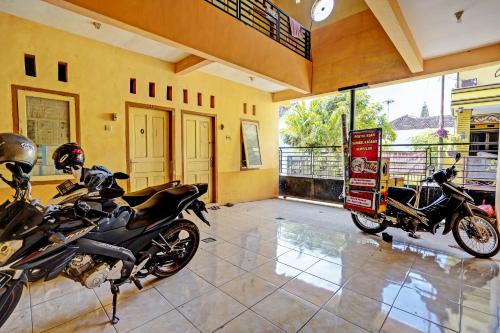 two motorcycles parked in a room with a building at Hotel O Lili Kost SyariahNearKetapang Royal City in Banyuwangi