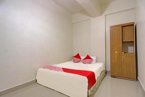 a bedroom with a bed with red pillows on it at Hotel O Octav Homestay in Nagoya