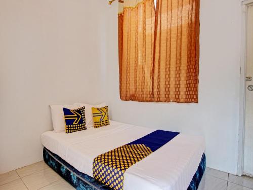 a small bedroom with a bed and a window at Hotel O Wisma Bani Pandi Syariah in Jepara