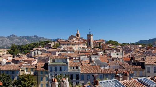 une ville avec des maisons et une tour d'horloge sur une colline dans l'établissement Un cabanon en Provence, à Aubagne